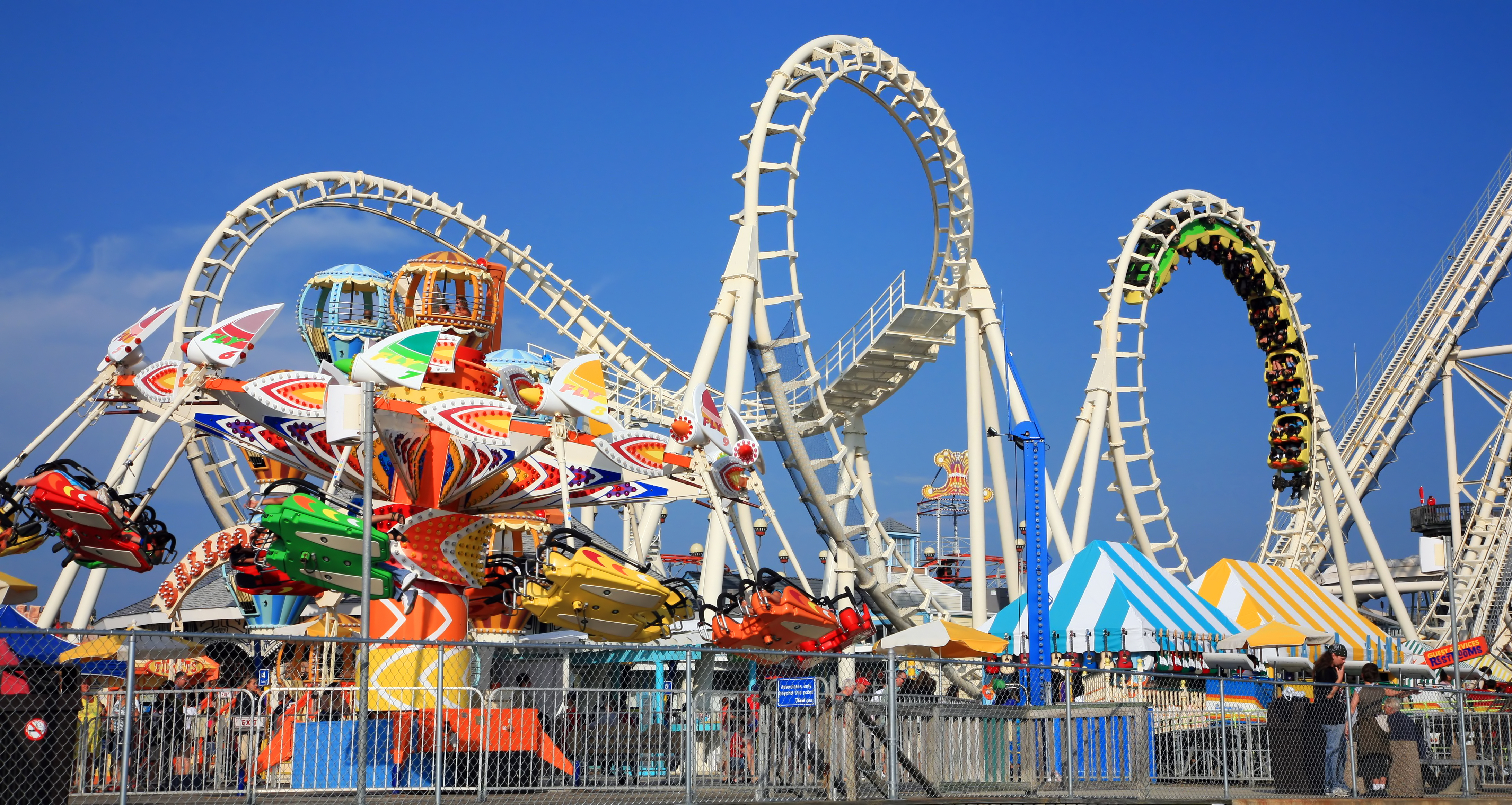 Vibrant fairground with a Ferris wheel and colorful rides at dusk